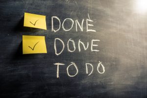 financial checkup concept of blackboard with checkmarks on yellow sticky notes