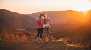 international women's day concept of two women looking out to mountain view sunset