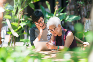 elder-care-grandson-grandma-tablet-outdoors